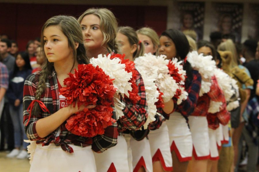 The cheerleaders stand together as the national anthem is played at a past pep rally