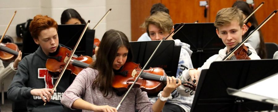 Orchestra students practicing their instruments