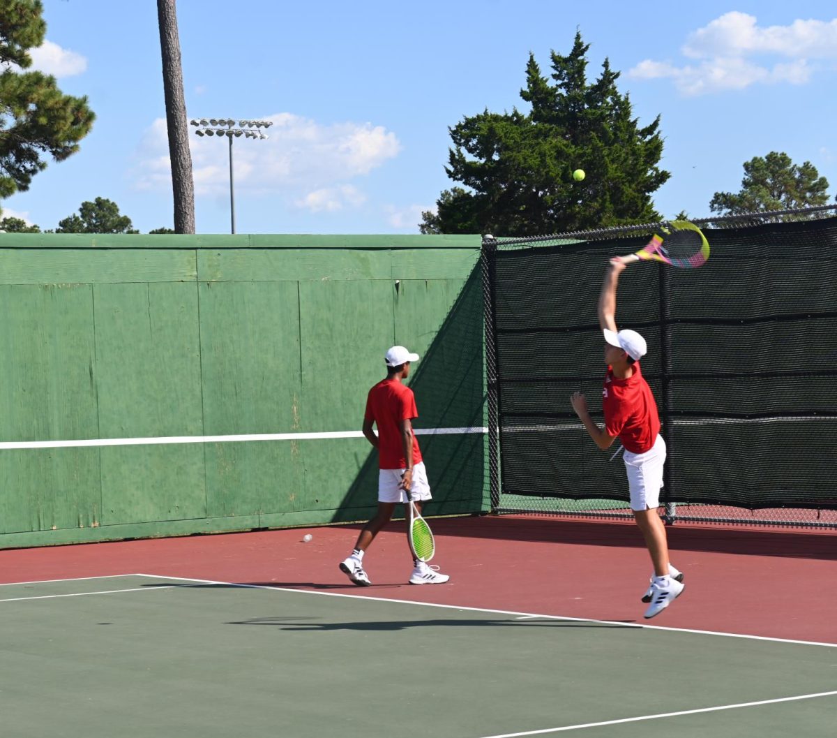 Tomball Tennis Boy's doubles practicing their serves.