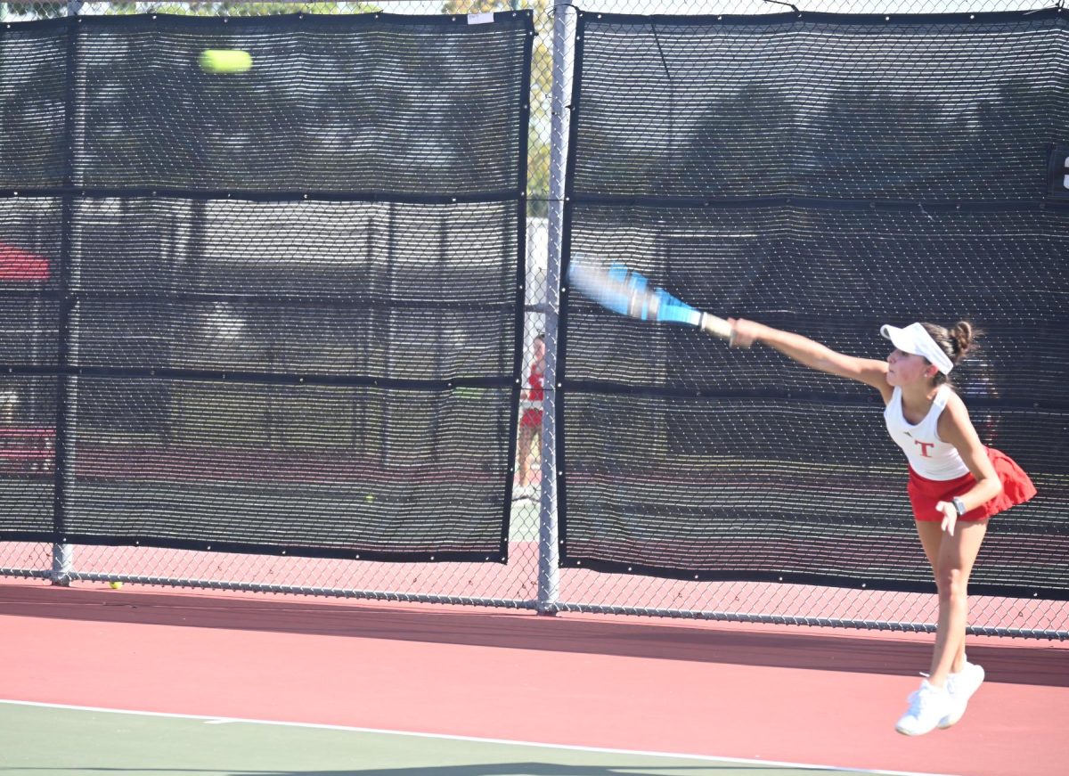 Tomball Tennis girl serving with all she has.