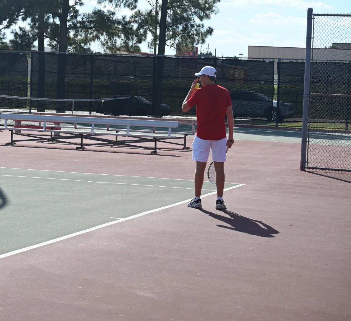 Tomball tennis player lining up his serve to hit it in.